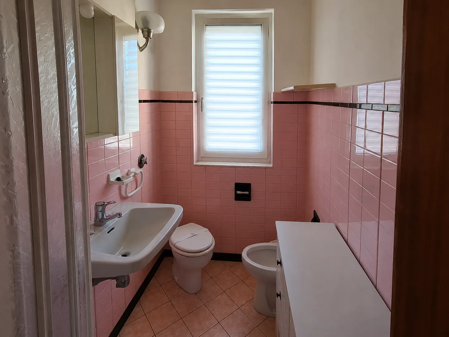 Bagno con rivestimenti rosa prima della ristrutturazione