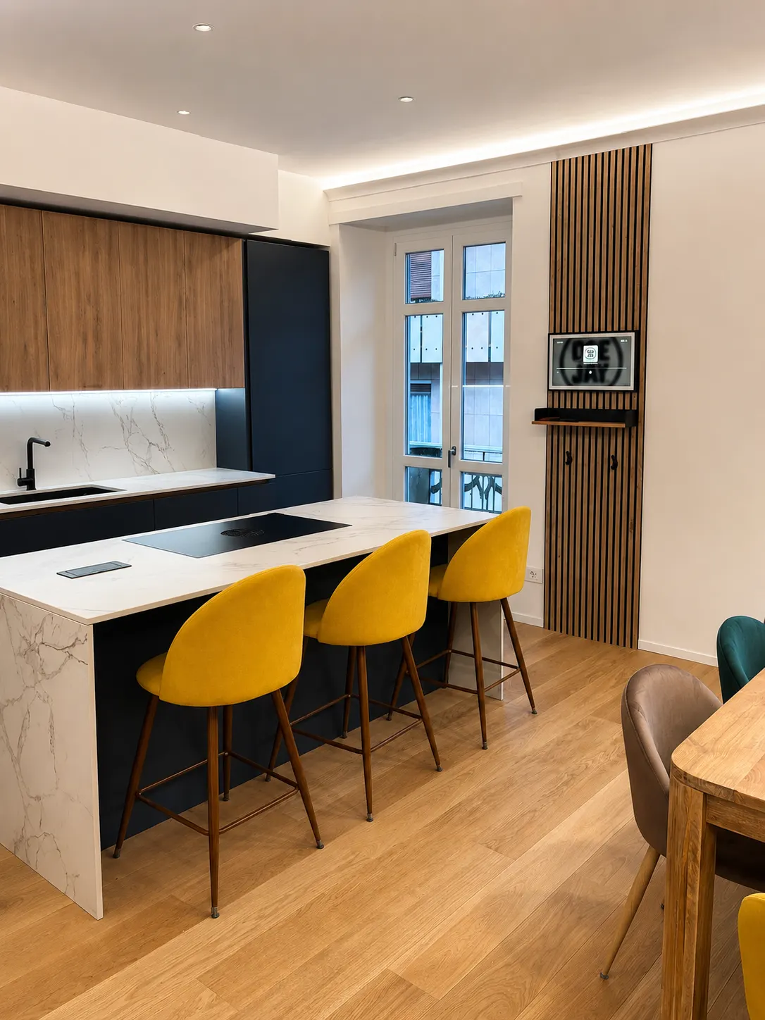 Zona giorno completata con cucina a isola e pareti a listelli